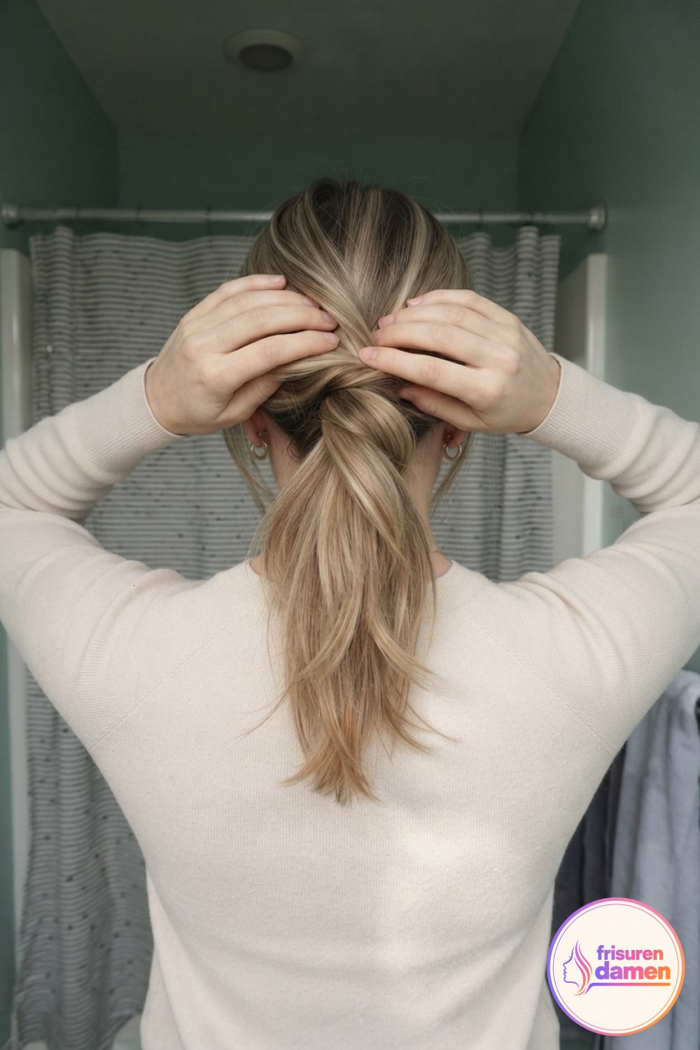 Beide Hände drehen das Haar locker Richtung Hinterkopf, der zentrale Schritt im lockeren Messy Bun Tutorial.
