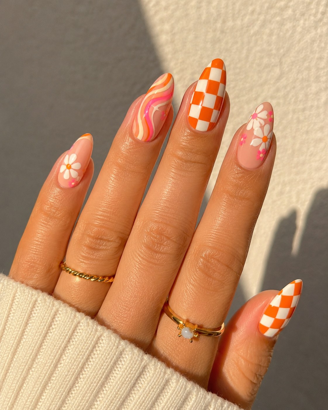 Retro-Karo in Orange mit Gänseblümchen und Swirl-Muster als verspielte Sommer Nägel 2026 Idee