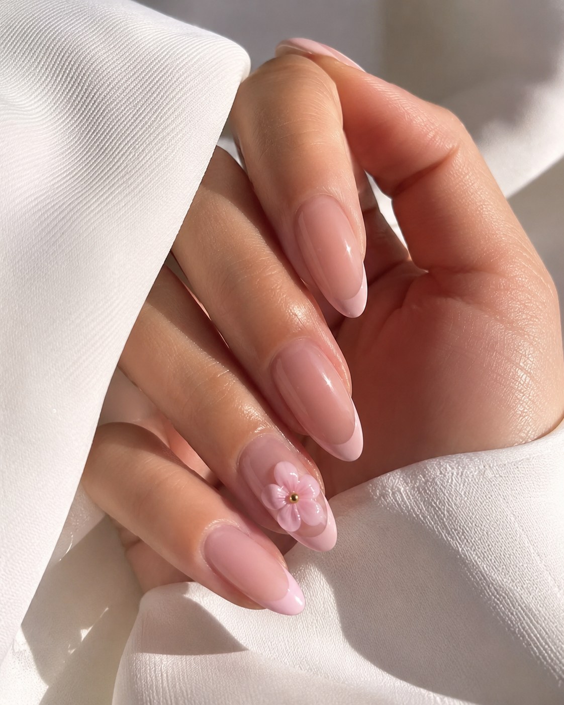 Nude Mandelnägel mit einer zarten Mini-Blüte als minimalistischer Sommer Nägel 2026 Alltagslook